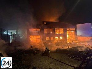 Bomberos extinguen incendio en gran nave industrial en Griñón, Madrid.