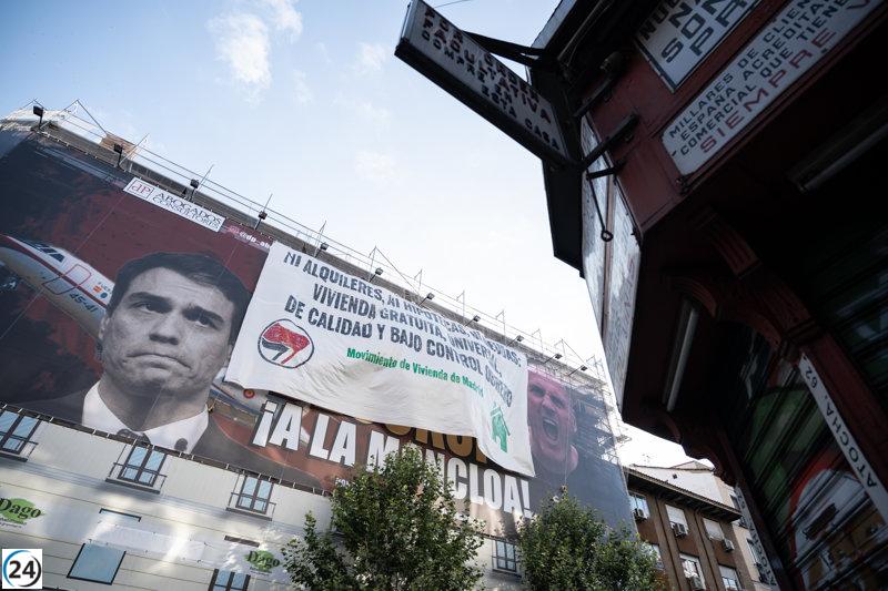 Activistas de izquierdas perturban la lona de Desokupa en calle de Atocha de Madrid.